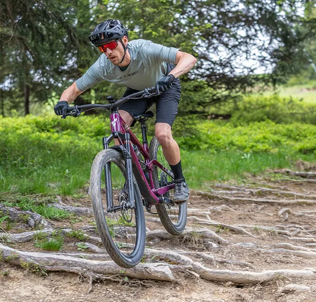 Cycliste sur VTT violet descendant un chemin forestier rocailleux à Nogent-sur-Marne dans le Val-de-Marne près de Montreuil 