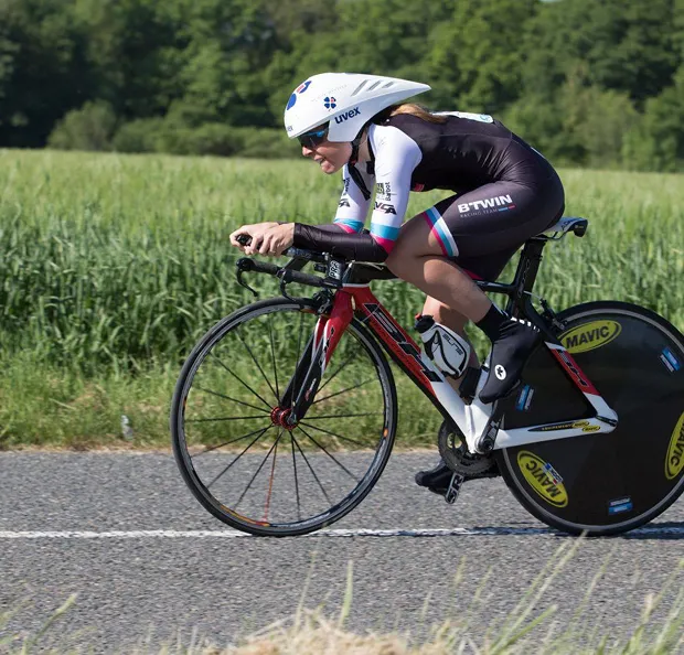 Cycliste en tenue de contre-la-montre sur un vélo de course rouge, en pleine action à Nogent-sur-Marne dans le Val-de-Marne près de Montreuil 