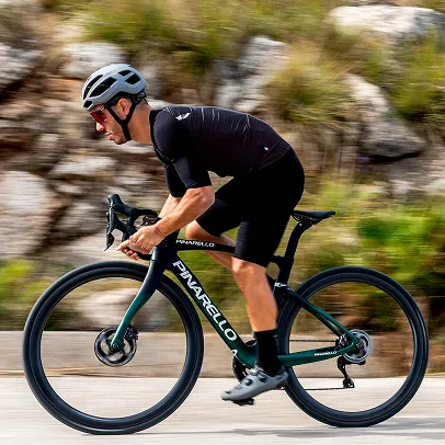 Cycliste masculin en noir sur un vélo Pinarello vert-noir, en mouvement sur une route à Nogent-Sur-Marne dans le Val-de-Marne près de Montreuil 