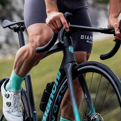 Cycliste en cuissard gris et chaussettes turquoises, mains sur le guidon de vélo noir à Nogent-sur-Marne dans le Val-de-Marne près de Montreuil 